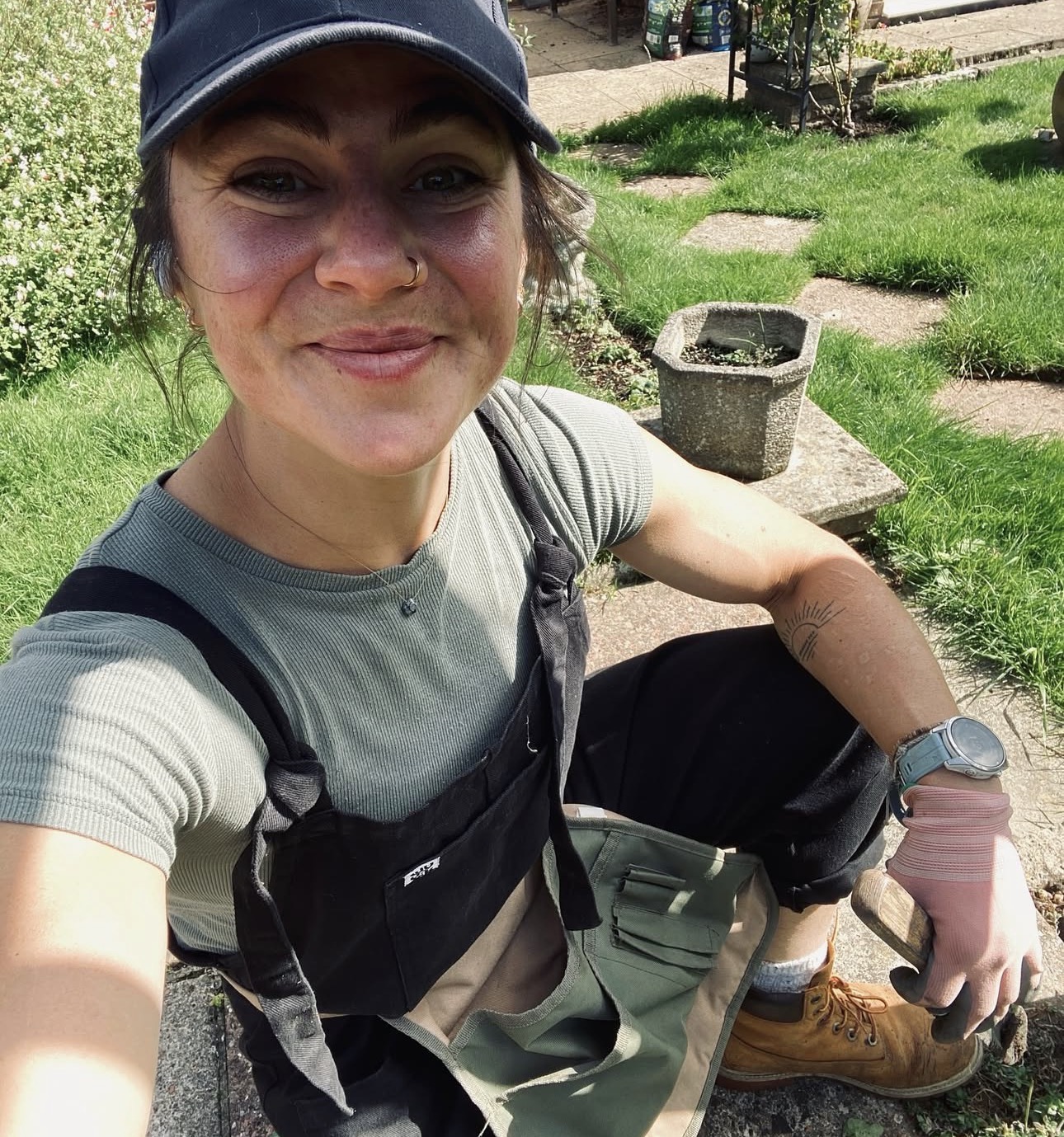 Portrait of Emelye Dwyer, smiling, in gardening overalls